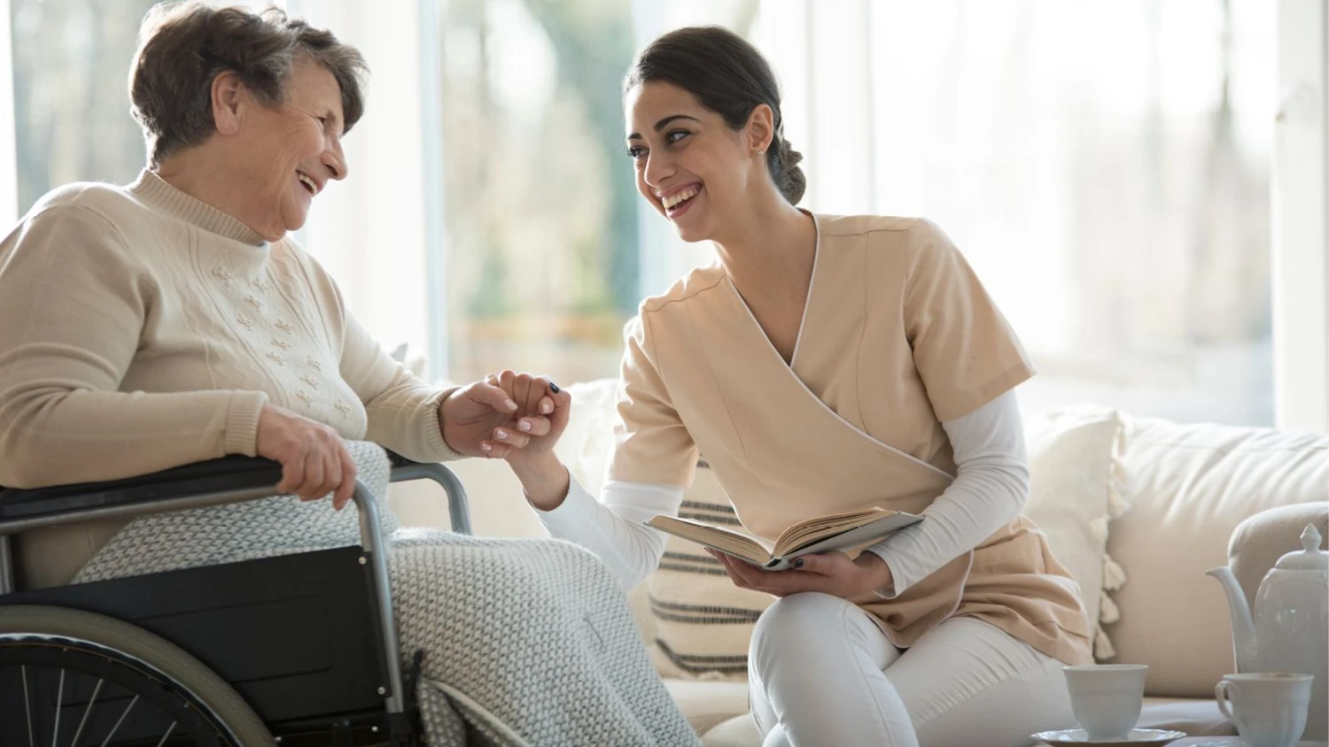 Betreuungsdienst Jaqueline - eine Krankenschwester liest einer alten Dame ein Buch vor