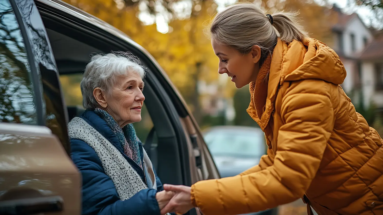 Helferin, die einer älteren Frau beim Aussteigen aus ihrem Auto hilft 