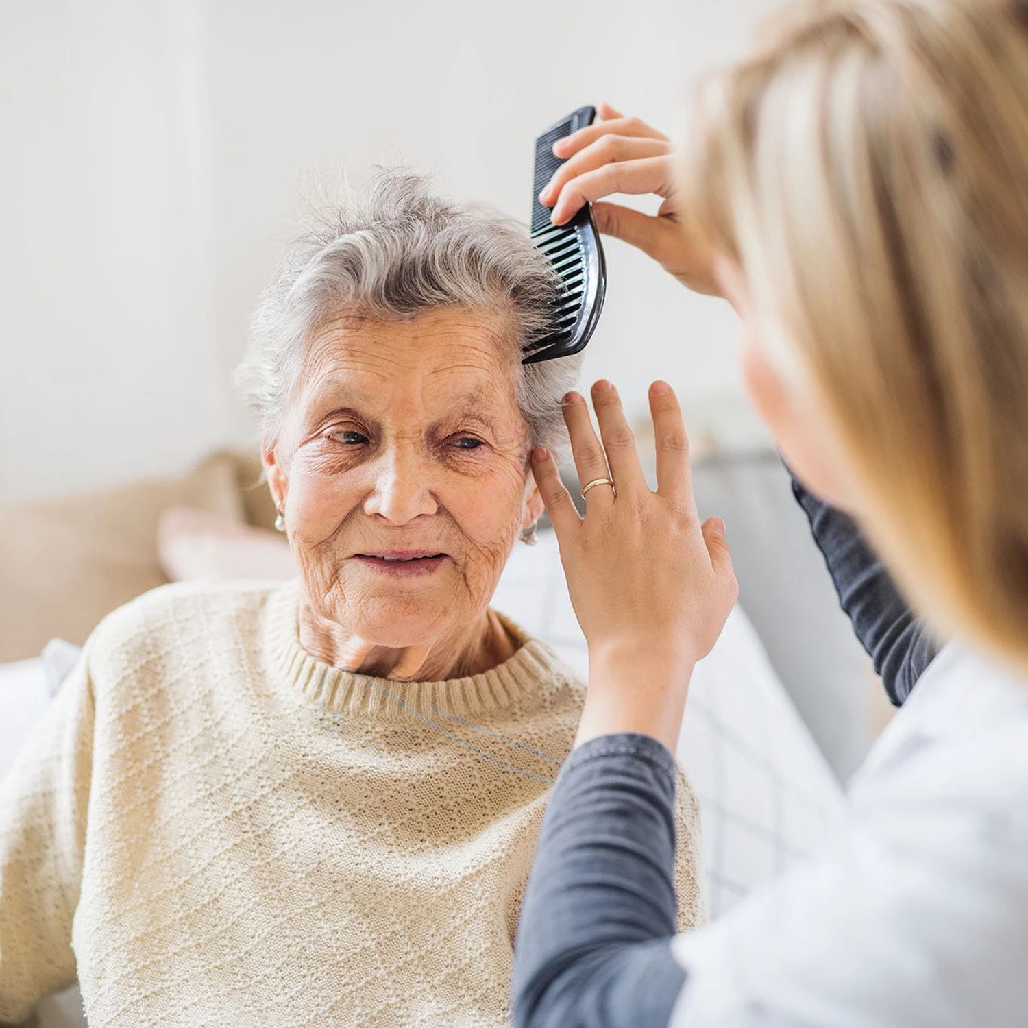 Betreuungsdienst Jaqueline - Eine Krankenschwester kämmt einer alten Dame die Haare